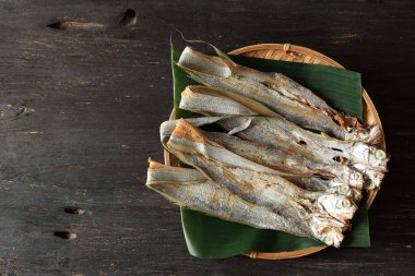 Ikan Asin Layur, Güneş Kurutulmuş Kılıçbalığı ya da Balık Kuşağı 'ndan yapılmış tuzlu balık. Bambu tepsisinde muz yaprağı ile servis edilir, metin için alanı kopyala 