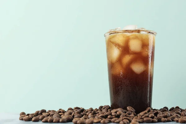Iced Americano Coffee with Coffee Beans on Light Background, Copy Space for Text