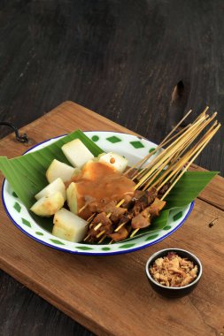 Sate Padang veya Satay Padang, Padang, West Sumatra 'dan Baharatlı Biftek Satay. Baharatlı köri sosu ve Ketupat Rice Cake, Lontong ile servis edilir.