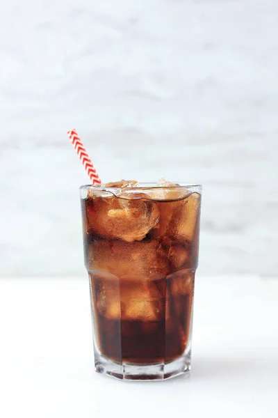 Iced Cola on Tall Glass with Red Stripes Paper Straw, on White Background. Isolated