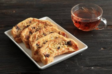 Muzlu, çıtır çıtır muzlu hamur işi, Puff Pastası, Muz, Süt, Yumurta, Izgara Peynirli Un. Bir fincan çayla servis edilir.