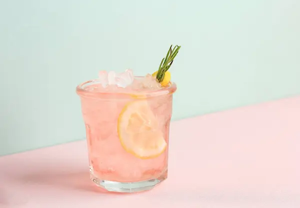 Pink Alcoholic Rose Lemon Beverage or Lemonade, Cocktail with Rosemary and Lemon Slice