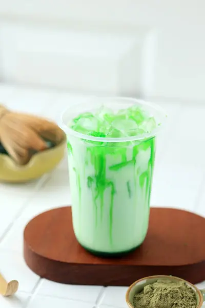 牛乳か水と混合される緑茶葉の粉から成っているアイスオーガニック自家製の健康なマッチャラテ — ストック写真
