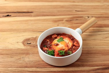 Shakshouka, domates sosunda haşlanmış yumurta, zeytinyağı, biber, soğan ve sarımsak. Tahta Masada Akdeniz Mutfağı 