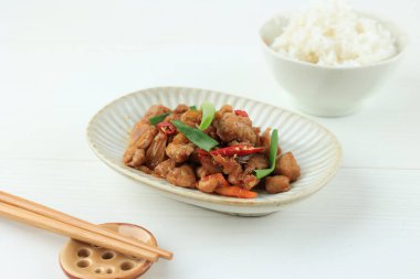 Kızarmış tavuğu acı biber, sarımsak ve taze soğanla karıştır. Pirinç ile servis edildi. 