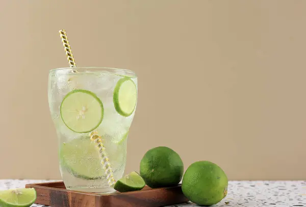 Refreshing Lime Soda with Ice Cube in Tall Glass with Paper Straw, Refreshing Beverage. Copy Space for Text