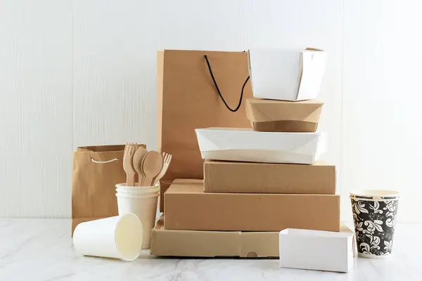 Paper Bags and Takeaway Food Packaging on White Table