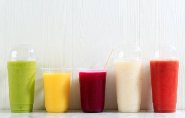 Plastik Kupa Paketinde, Beyaz Masa Arkaplanında Farklı Renk Suyu 