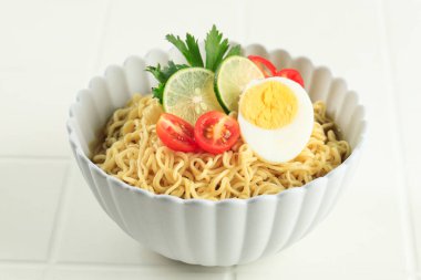 Indomie Rebus veya Soto Lezzetli Anında Kaynamış Erişte, haşlanmış yumurta, domates ve dilimlenmiş limon ile Endonezya Anında Erişte