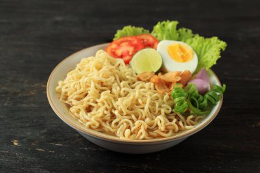 Indomie Rebus veya haşlanmış yumurta, domates ve dilimlenmiş limonlu şehriye. Indomie Ayam Bawang