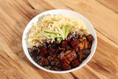 Jajangmyeon or Jjajangmyeon, Korean Noodle with Black Sauce on White Plate, Topping with Roasted Sesame Seed and Cucumber Kyuri clipart