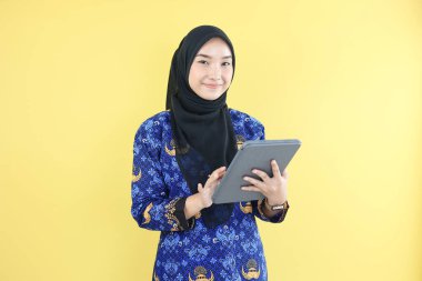 Korpri Batik Üniformalı Genç Kadın ASN Hükümet İşçisi. Sarı Arkaplanda İzole Edildi