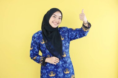 Kadın Hükümet İşçisi İyi Başparmak Hareketi Yapıyor, Batik Korpri Üniforması ve Başörtüsü Giyiyor 