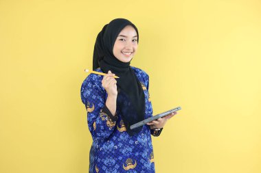 Neşeli Müslüman Hükümet İşçisi veya Mavi Korpri Batik Üniformalı Kadın Delik Tab ve Kalem 