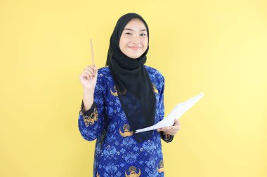 Korpri Batik Üniformalı Genç Kadın Başörtüsü Askısı Hükümet İşçisi Kalem tutuyor, Belge Kontrol Ediyor