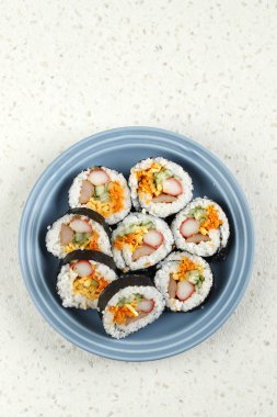 Kore usulü pirinç veya Gimbap, mavi tabakta servis edilir. 
