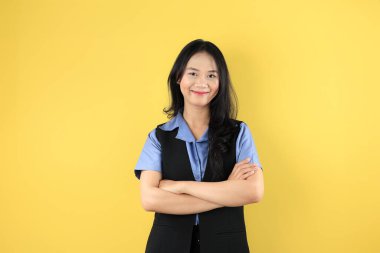 Gülümseyen Asyalı Güzel İş Kadını 'nın portresi Kolları Sarı Arkaplanda çaprazlanmış