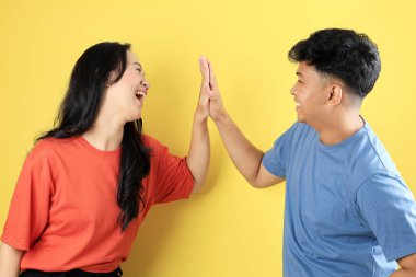 Sarı Arkaplanda Mutlu Yüzlü İki Genç Asyalı Arkadaş Çak Beşlik 