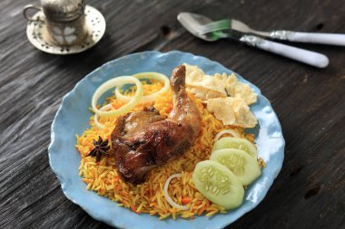 Nasi Kebuli Kabli Ayam Tavuk Pilav Mavi Tabakta, Tahta Masa üzerinde çay ile servis edilir 
