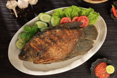 Top View Ikan Gurame Goreng, Çok Kızarmış Gourami Endonezya Sambal Baharat Sosu ve Marul ve Domates ile servis ediliyor 