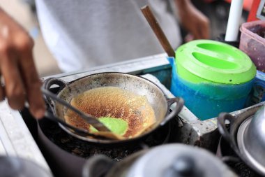 Satıcı Maymun Pandan 'ı Küçük Mutfak Malzemeleri ile Pişiriyor. Kue Tete Endonezya 'da Geleneksel İnce Krep Popüler Sokak Yemeği 