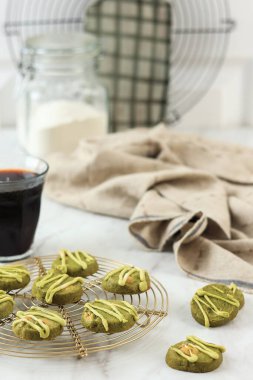Yeşil çay samuru kurabiyeleri bademli, sade kahveyle servis ediliyor. Boşluğu Beyaz Tabloya Kopyala 