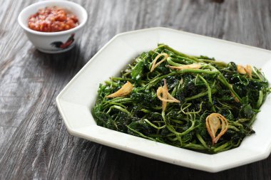 Jukut Goreng veya Selada Air Goreng, Kara Tahta Masa 'da Kızarmış Tuz ve Kızarmış Soğanlı Su Teresi 