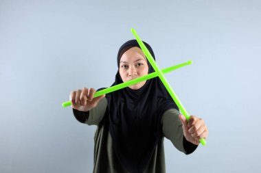 Yeşil Çubukla Poundfit Rockstar antrenmanı yapan kadın Müslüman, Gri Arkaplan 'da izole edilmiş.