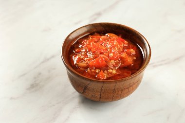 Endonezya Sambel Torbası ya da Baharatlı Sarımsaklı Biber Sosu, Tahta Kasede, Beyaz Masanın Üzerinde. Metin için Boşluğu Kopyala