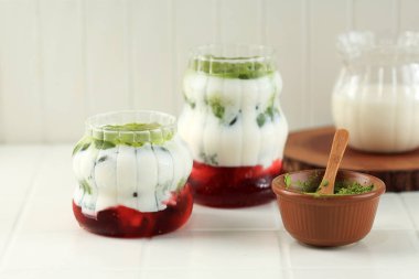Beyaz Masada iki bardak Matcha Strawberry Latte, Sütlü Çilek Reçeli ve Matcha Latte 