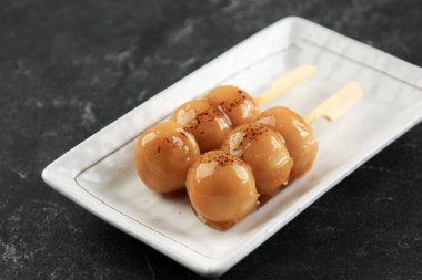 Mitarashi Dango, tatlı soya soslu Japon tatlısı. Beyaz Tabakta Servis 