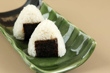 İki Onigiri Japon Pirinç Topunu Yeşil Japon Tabağı üzerinde Nori Laver ile kapat 