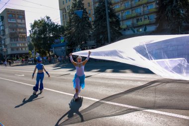Dnipro, Ukrayna - 09.11.2021: Vatandaşlar Şehir Gününü kutluyor. Paten yapan dansçılar bayrak sallıyor..