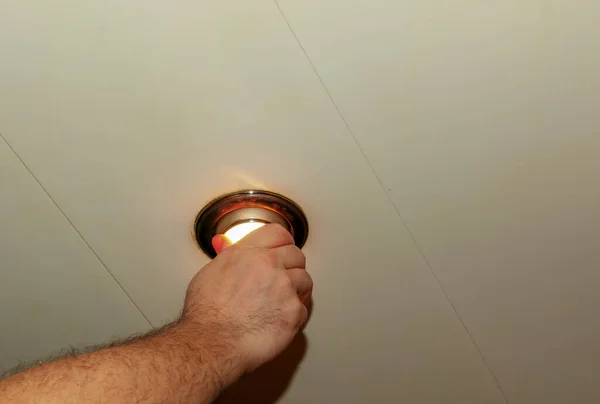 スポットライトを設置すると 手はランプを天井に挿入します 白熱電球を交換する — ストック写真
