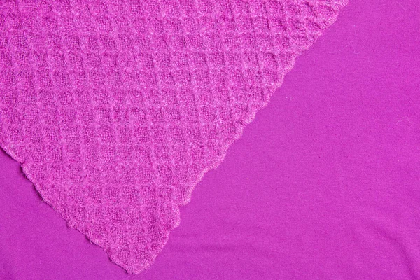 Lilac-pink knitted carpet close-up. Textile texture on a lilac-pink background. Detailed warm yarn background. Natural wool fabric, sweater fragment.