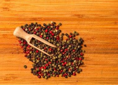 Baharatlı ahşap gıda arka planı. Mutfak tahtasının üzerinde tahta kaşıkla biber karışımı bir şey..