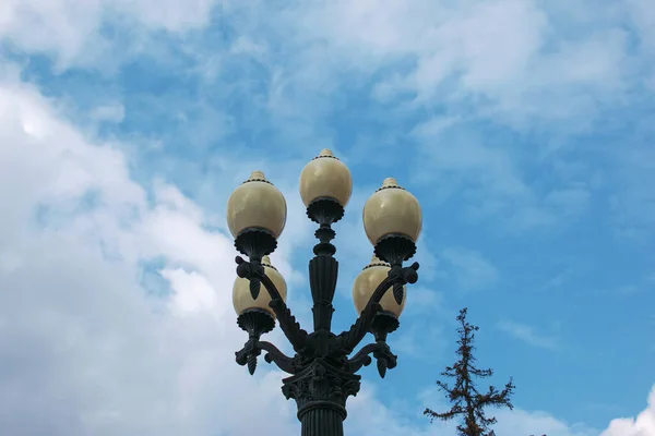 Street lamps on Metal pole against the background of cloudy blue sky by Afternoon sun. Selective focus.