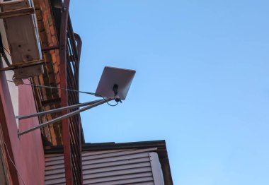 Starlink satellite dish, an internet constellation operated by SpaceX, is installed on the wall of an apartment building.