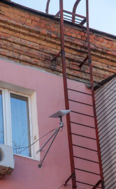 Starlink satellite dish, an internet constellation operated by SpaceX, is installed on the wall of an apartment building.