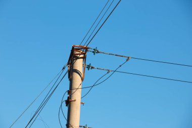 Electric pole with a linear wire against the blue sky close-up. Power electric pole.