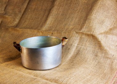 An old aluminum pan made in circa 1960 against a background of burlap.