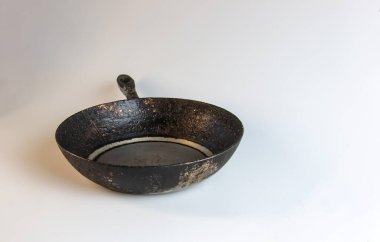 An old cast iron skillet made in circa 1960 against a white background.