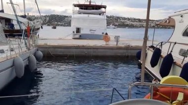 Bodrum, Turkey - 10.14.2021: Stern mooring of a sailboat in the dock at the sea pier. View from the stern of the yacht.