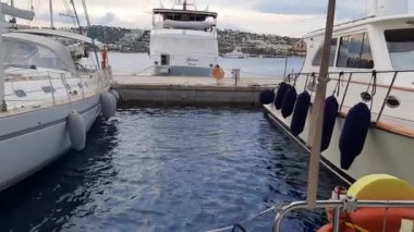 Bodrum, Türkiye - 10.14.2021: Rıhtımdaki bir yelkenlinin iskeleye demir atması. Yatın kıç tarafından bak..