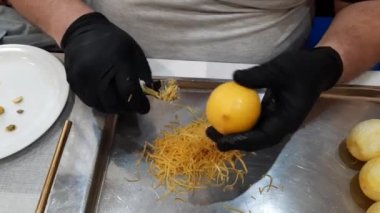 Siyah eldivenli erkek eller özel bir bıçakla limonun tadını alıyor..