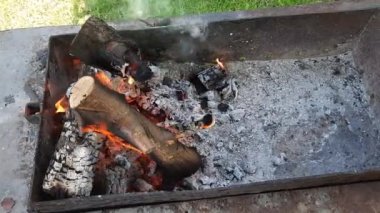 Ateş ve odun, odunlarla dolu bir makinede parlak bir şekilde yanıyor.