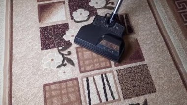Elektrikli süpürgeyi kapat, fırçaya odaklan, halıyı temizle. Ev, temizlik konsepti. 