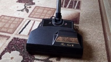 Elektrikli süpürgeyi kapat, fırçaya odaklan, halıyı temizle. Ev, temizlik konsepti. 
