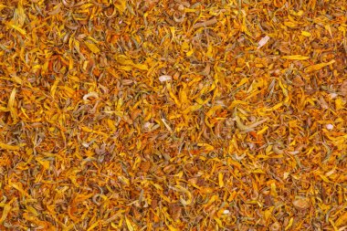 Bitkisel ilaçlarda kullanılan kuru otların arka planı CALENDULAE FLORES veya Marigold yaprakları. Bitkisel tedavi kavramı. Etkin bileşen CALENDULA OFFICINALIS