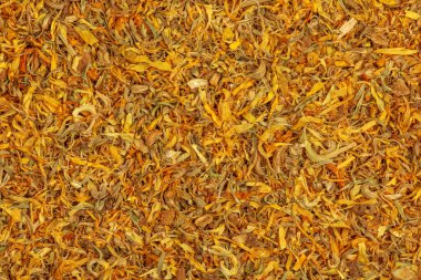 Bitkisel ilaçlarda kullanılan kuru otların arka planı CALENDULAE FLORES veya Marigold yaprakları. Bitkisel tedavi kavramı. Etkin bileşen CALENDULA OFFICINALIS